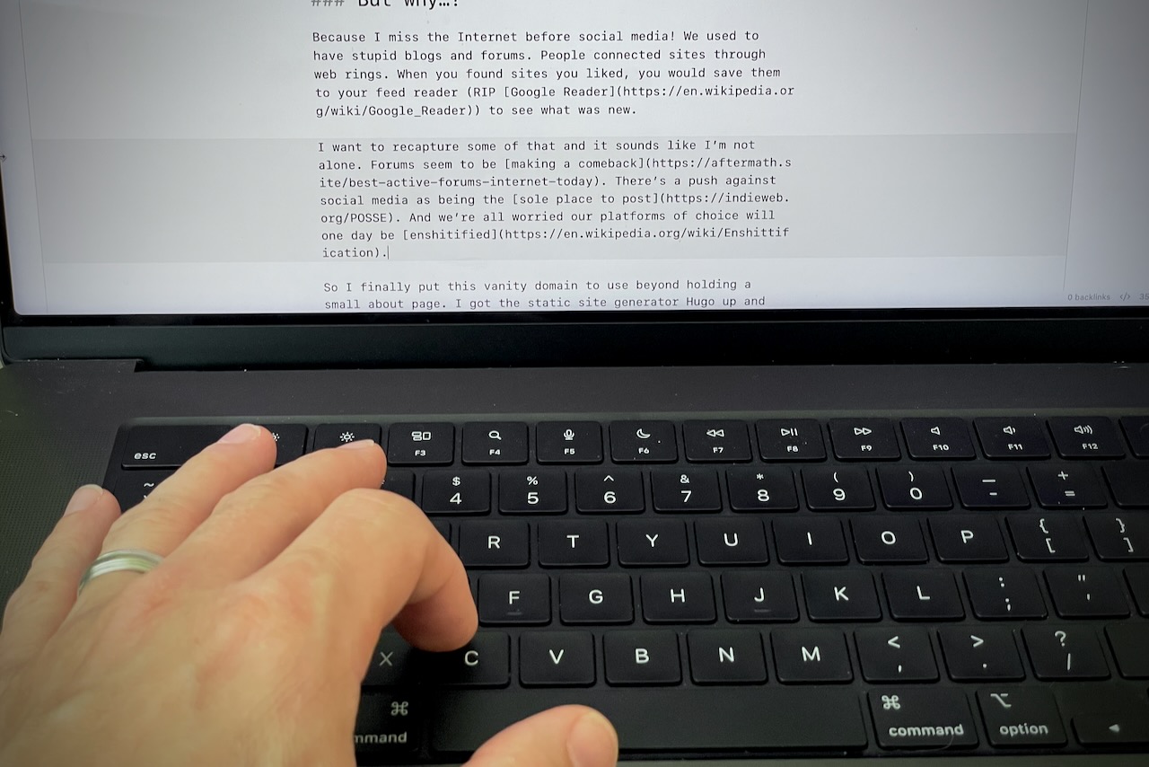 tight framing of draft blog post on a laptop screen with a hand typing on a keyboard below