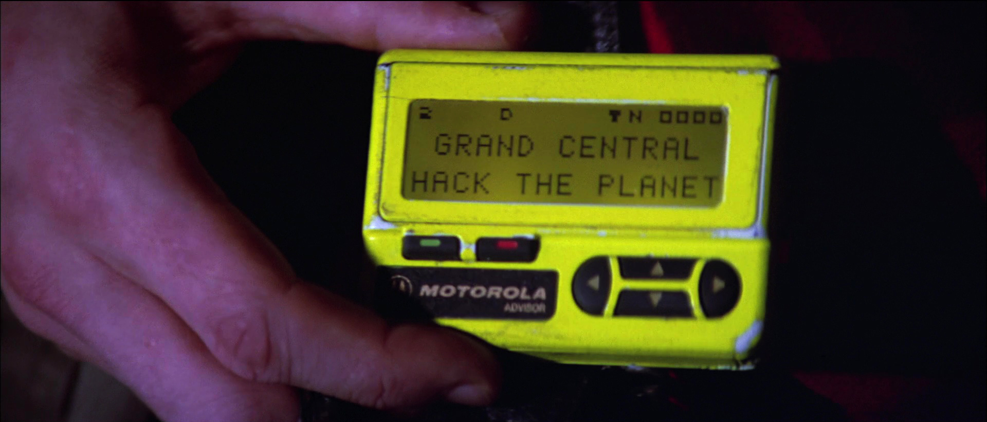 Neon yellow pager displaying “Grand Central Hack The Planet” from the film.