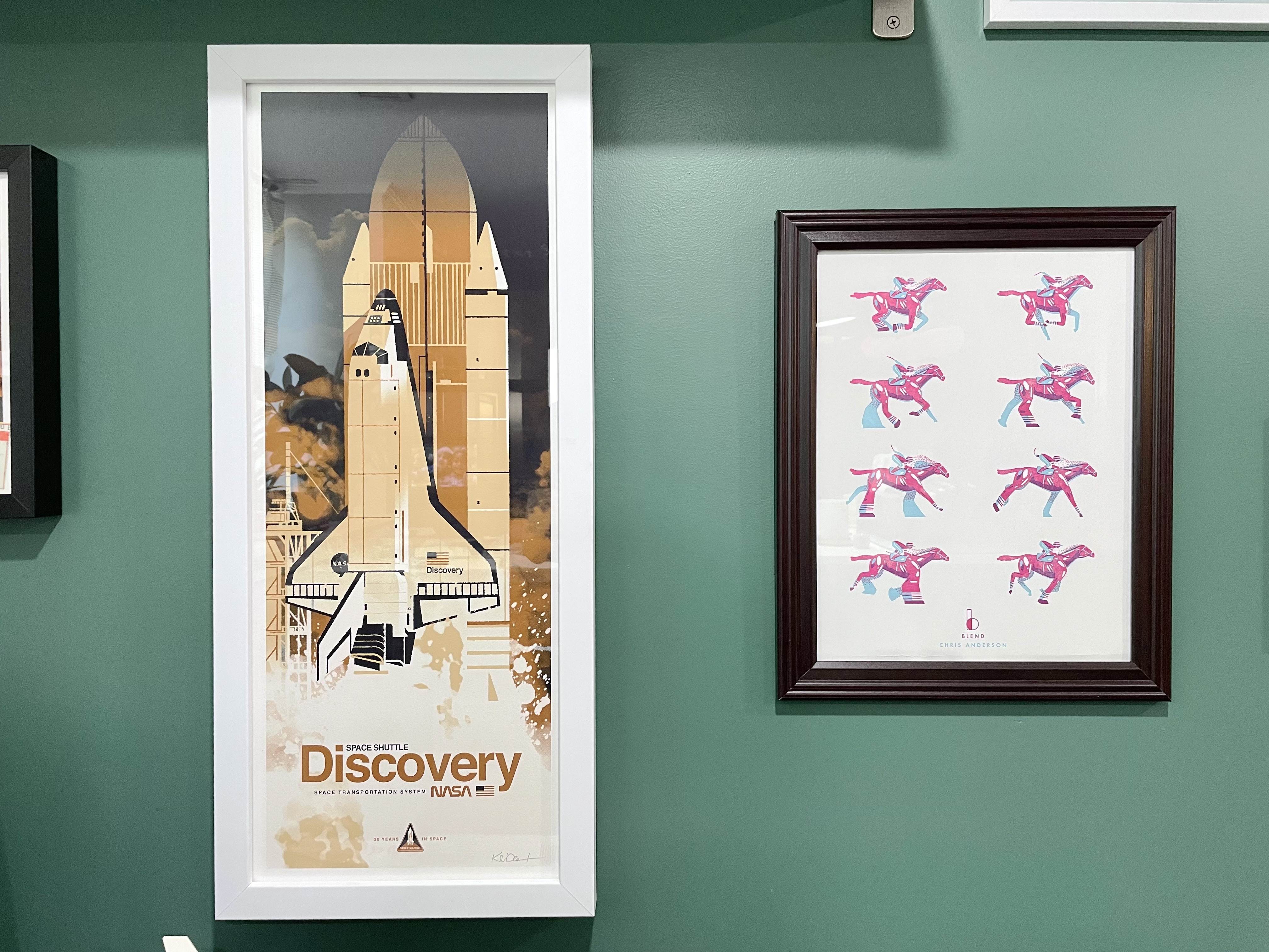 Framed art of the space shuttle Discovery and frames of an illustrated horse running